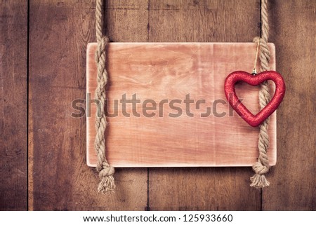 Valentine heart, wooden frame with rope hanging on planks background