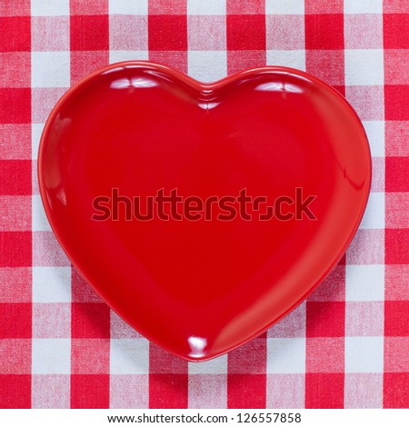 Valentine heart plate on checkered red and white tablecloth background