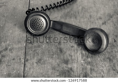 Vintage telephone handset on old wooden table background