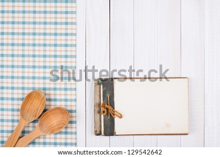 Recipe notebook, tablecloth on white wood background