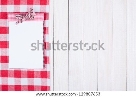 Red and white tablecloth, recipe book on wooden background