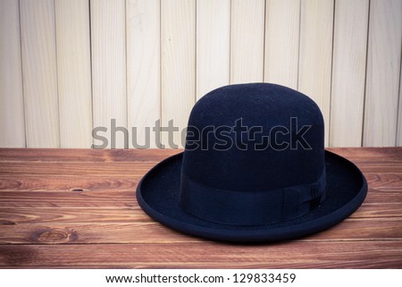 Black man hat on table near wood wall vintage photo