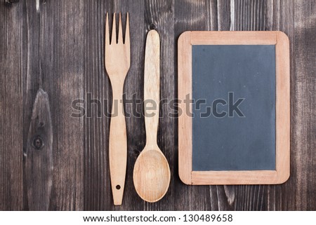 Menu black board, spoon, fork on wood background