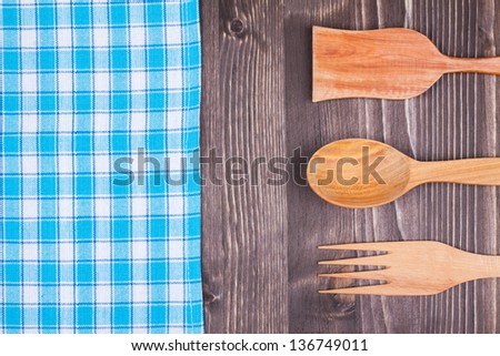 Blue and white checkered tablecloth, fork, spoon on white wood background