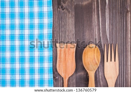 Blue and white checkered tablecloth, fork, spoon on white wood background