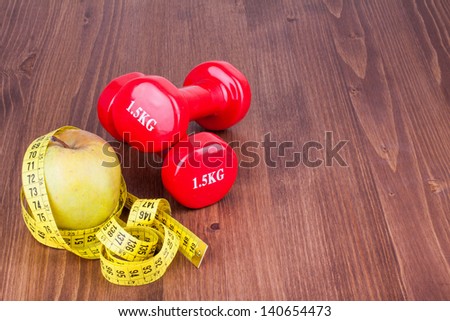 Diet apple, measure tape and fitness sport dumbbells