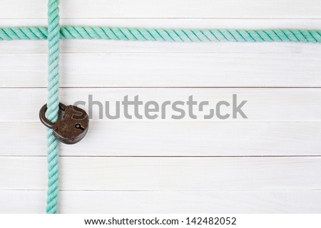 Rope frame, old lock on white wood planks background
