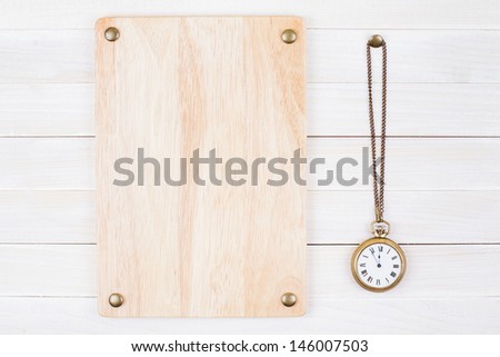 Vintage bronze pocket watch, signboard on white wood wall background