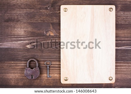 Sign board, old lock, key on vintage wood planks background