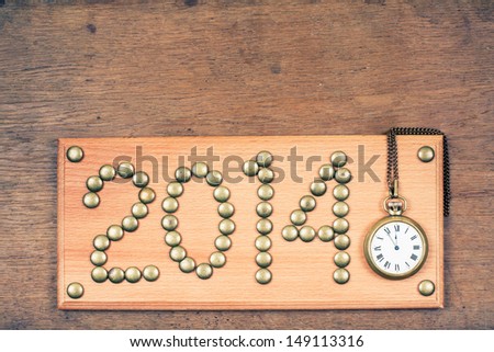 Vintage New Year date sign board on wooden background with clock
