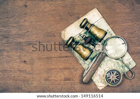 Vintage Binoculars, Compass, Old Map, Magnifying Glass, Pocket Knife On Wooden Background