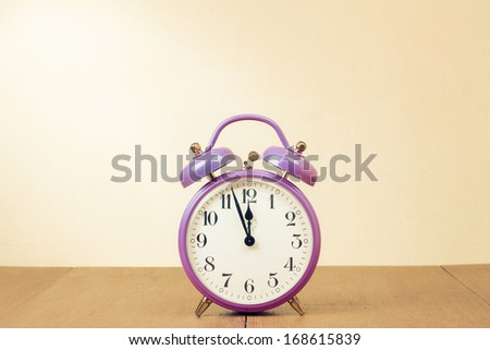 Retro alarm clock with five minutes to twelve o'clock