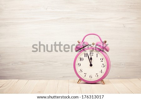 Retro alarm clock with five minutes to twelve o\'clock