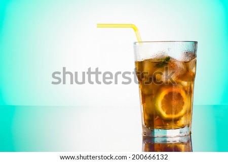 Glass of Long Island iced tea front mint green gradient background