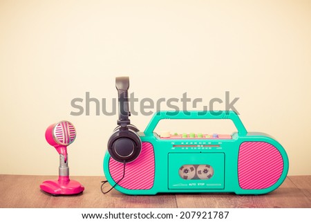 Retro radio cassette recorder, microphone and headphones on table
