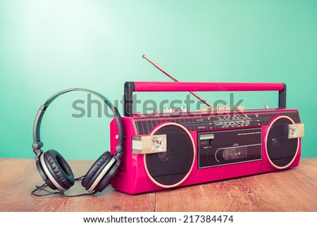 Retro radio cassette recorder from 80s, headphones front mint green background