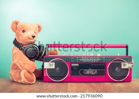 Teddy Bear with headphones and retro radio recorder front mint green background