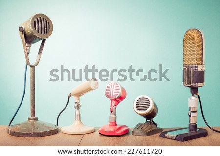 Old retro microphones for press conference or interview front mint green wall background