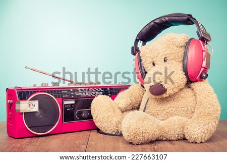 Teddy Bear with red headphones and retro radio cassette recorder from 80s