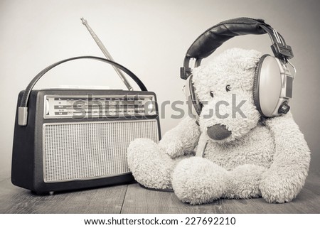 Teddy Bear with headphones and retro radio. Vintage old style sepia photo