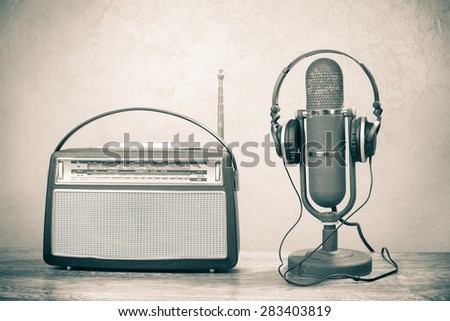 Retro radio from 60s, old ribbon studio microphone and headphones. Vintage style sepia photo