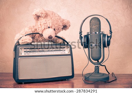 Teddy Bear toy, retro radio from 60s, old microphone with headphones. Vintage style instagram filtered conceptual photo