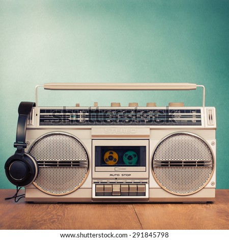 Retro radio recorder from 80s and headphones front mint green background. Vintage old style instagram filtered photo