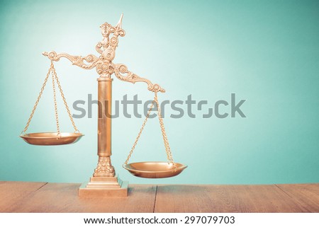 Bronze law scales on table. Symbol of justice. Retro old style filtered photo