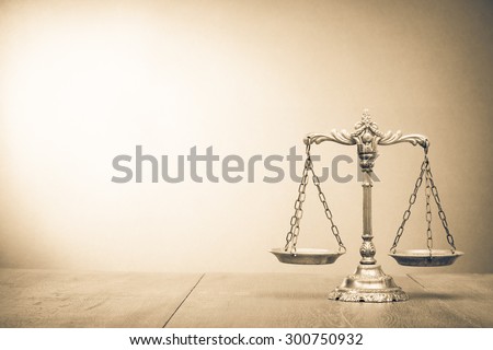 Retro law scales on table. Symbol of justice. Vintage style sepia photo