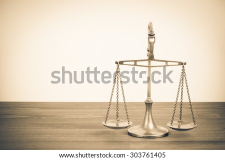 Retro law scales on table. Symbol of justice. Vintage style sepia photo