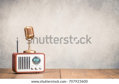 FM radio receiver and golden microphone front concrete wall background. Listening music concept. Vintage old instagram style filtered photo