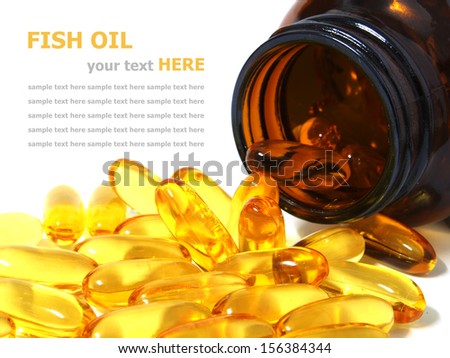 Pile of omega 3 fish oil capsules spilling out of a bottle