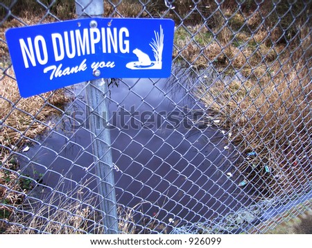 Piles of trash just beyond a \'No Dumping\' sign
