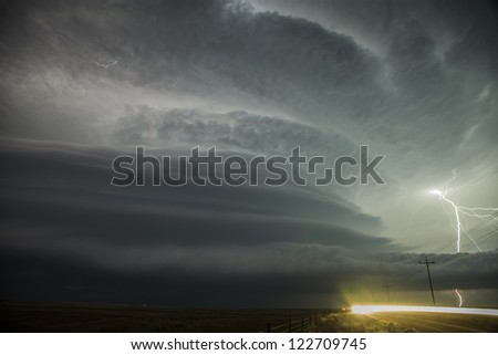 Super-cell thunderstorm with lightning & oncoming headlights