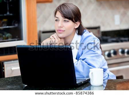 Woman in robe using laptop computer over coffee