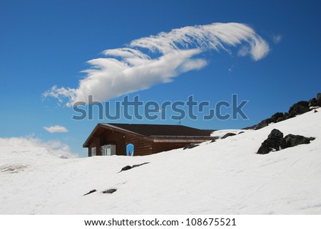 Cloud over ski club building covered by snow in winter. Mt Ruapehu. New Zealand