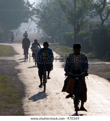 Cycling to work & school in early morning haze. Myanmar (Burma)