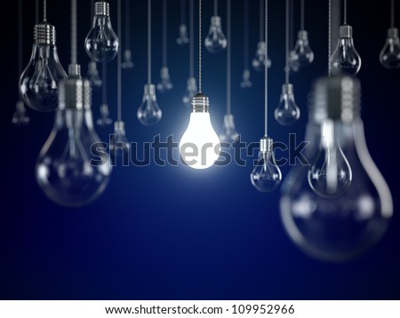 Hanging light bulbs with glowing one isolated on dark blue background