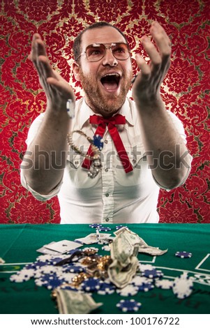 A man wearing glasses, a white shirt, and a red Texas tie sits at a blackjack table. He smiles hugely as tosses his winnings in the air./Happy Man Gets Rich at Blackjack