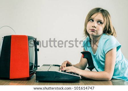 Female child typing on vintage keyboard, looking bored, with video game joystick and TV