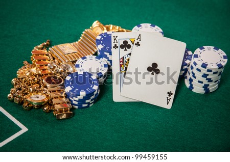 Blackjack 21 hand of a King and an Ace playing Cards on Casino green felt with chips and gold jewelry