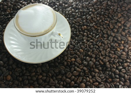 Cup with cappuccino, costing on coffee grain