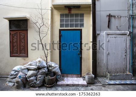 New blue door, an old white door and window in the slums
