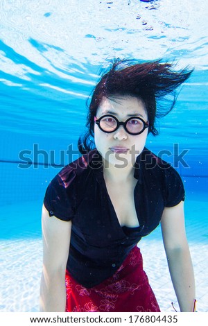 Asian young woman in business clothes and glasses  under water