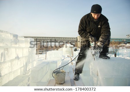 Novosibirsk, Russia - December 18: Man cuts through ice sculpture with a chainsaw. Construction of the ice camp on the river Ob, December 18, 2008, Novosibirsk, Russia