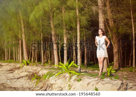 Beautiful romantic woman in tropic forest on sunset