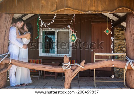 Young beautiful happy couple in love near wooden house