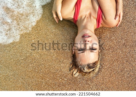 Beautiful wet woman face with water drop. Close-up portrait on the beach background