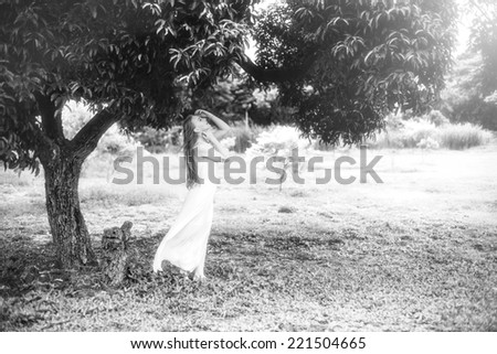 Beautiful woman in white dress in nature, black and white photo