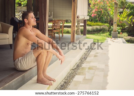 Yang man sitting on his luxury villa, thinking and relax
